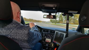 Auto Express products editor Kim Adams driving a Volkswagen Golf Mk7 on track